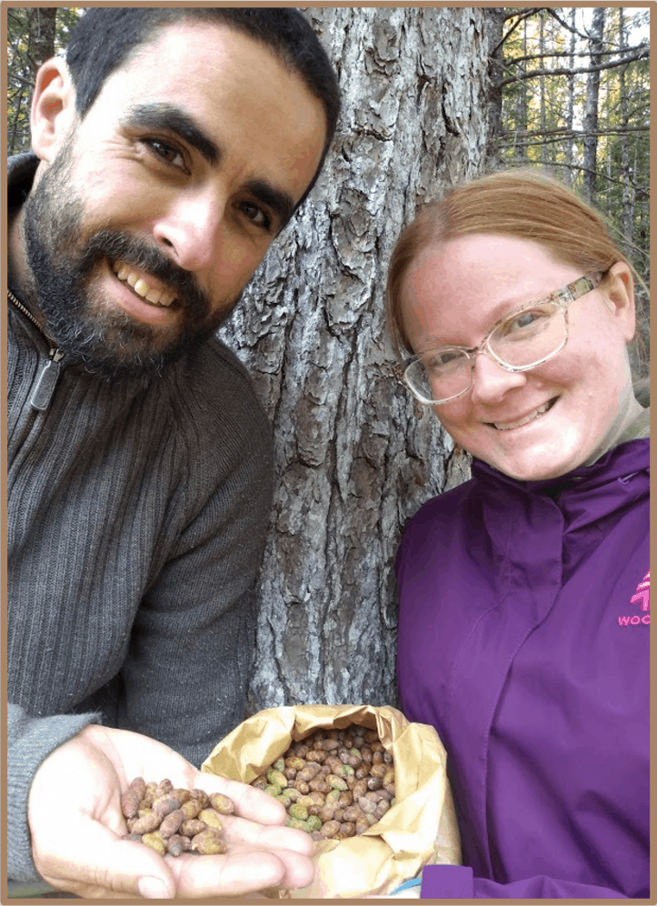 Alain and Sarah holding a bag of hemlock seeds they collected