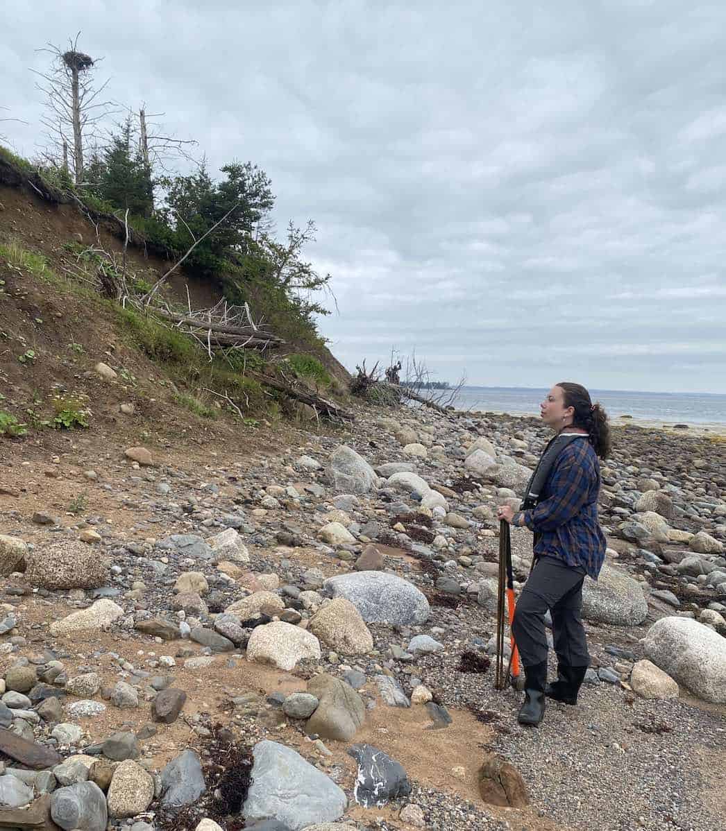 Student Natalie surveying the coast of an island for locations to sample